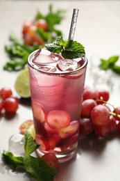 Photo of Soda water with grapes, ice and mint on table. Refreshing drink