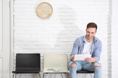 Young man waiting for job interview, indoors