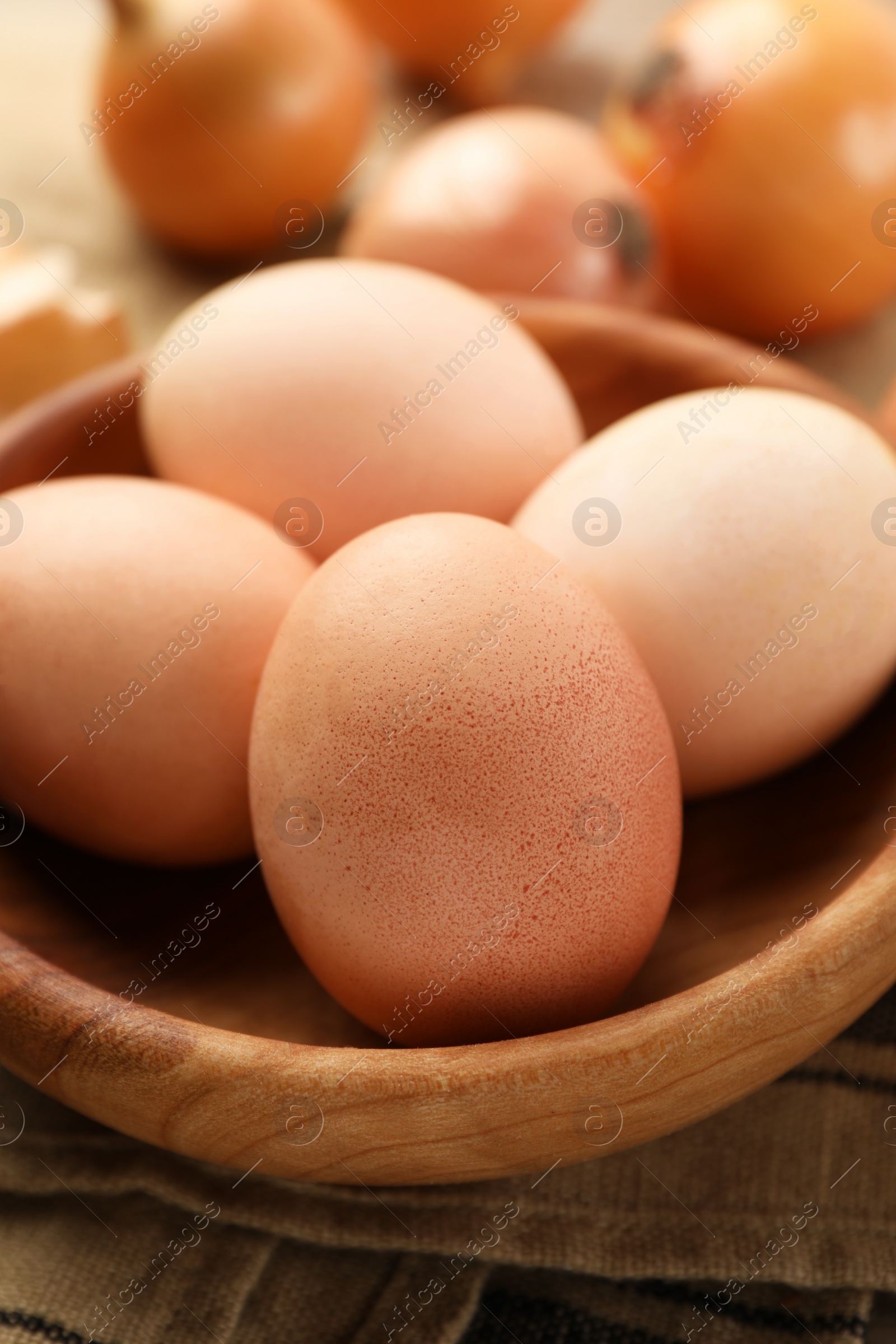 Photo of Easter eggs painted with natural dye in wooden bowl on table, closeup