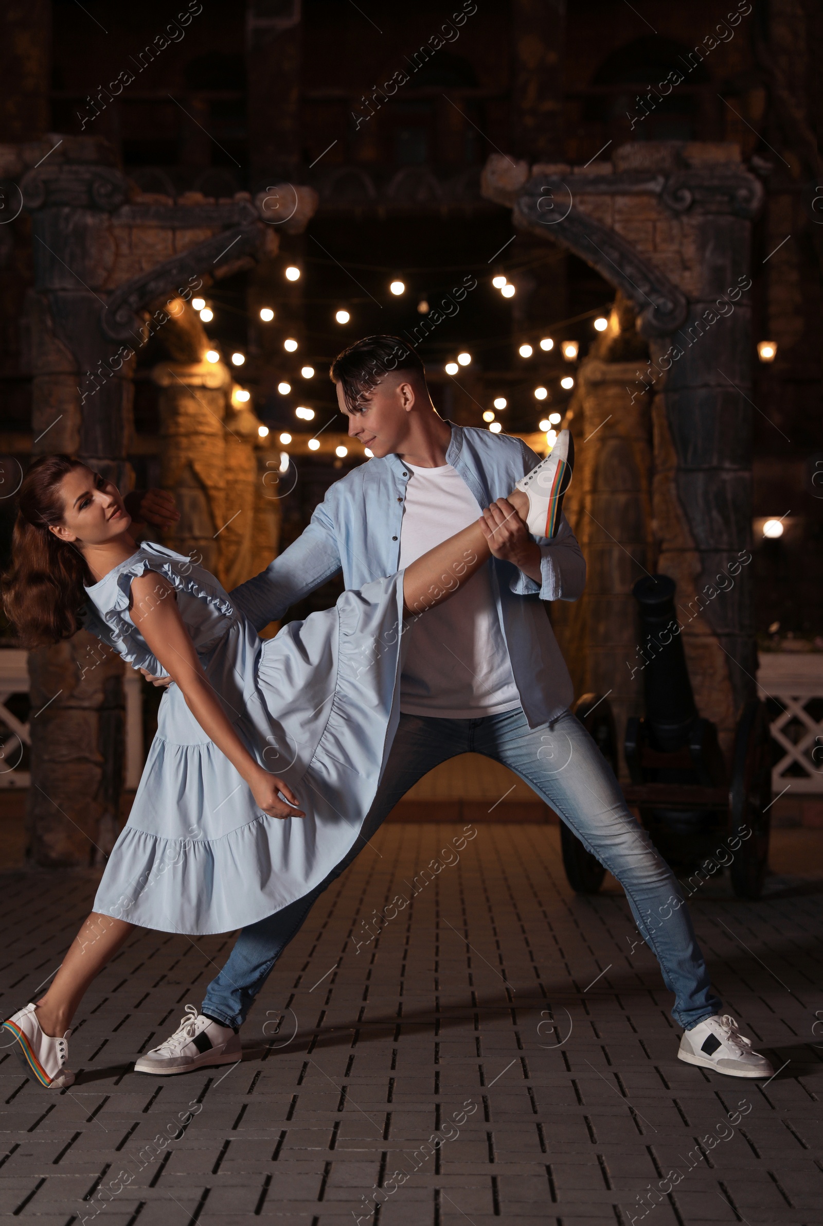 Photo of Beautiful young couple practicing dance moves in evening outdoors