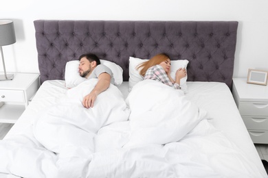Couple sleeping back to back in bed at home. Relationship problems