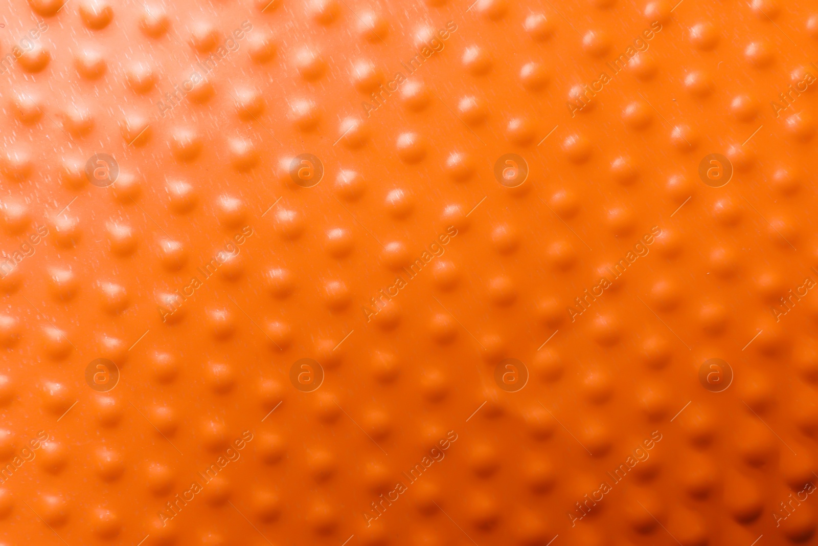 Photo of Texture of orange plastic cup as background, closeup