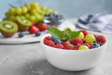 Photo of Fresh tasty fruit salad on grey marble table