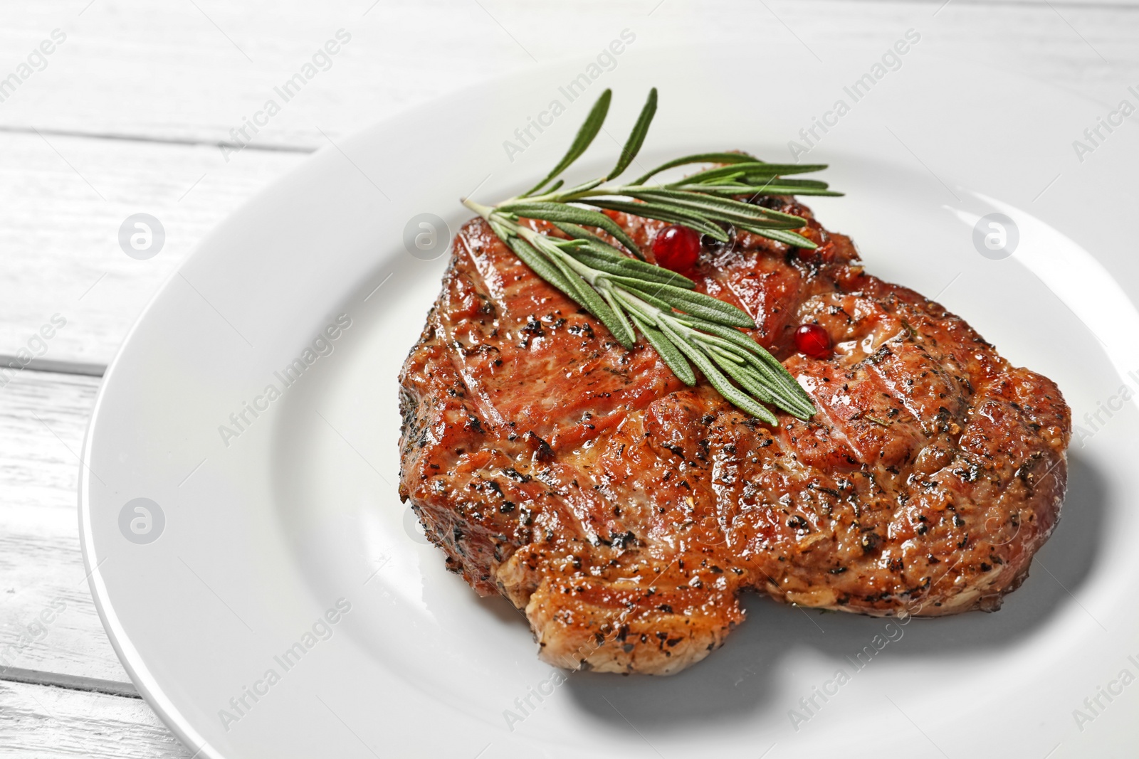 Photo of Plate with tasty grilled meat on table, closeup