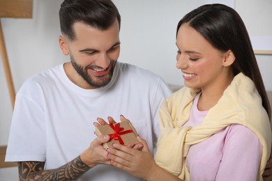 Photo of Lovely couple with beautiful gift at home