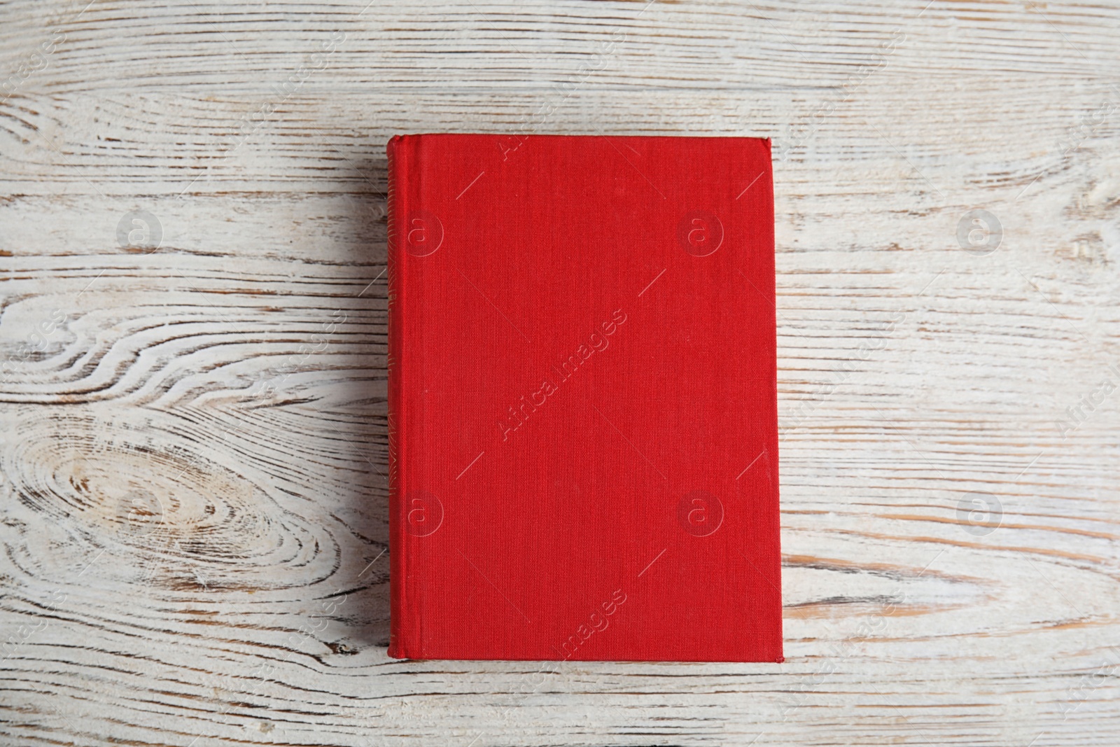 Photo of Hardcover book on light wooden  table, top view. Space for text