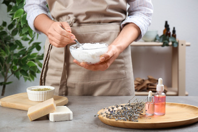 Woman making natural handmade soap over grey stone table, closeup