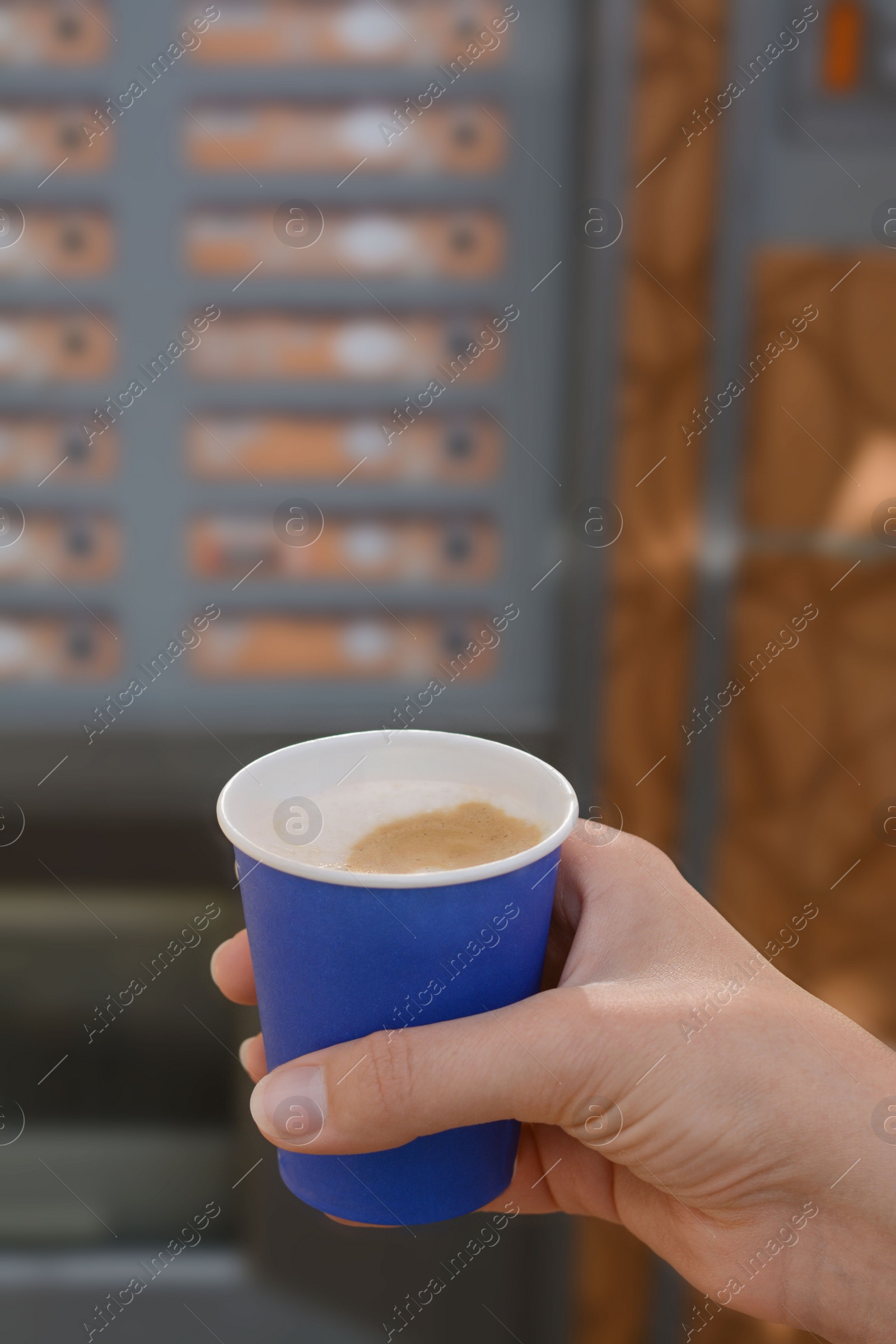 Photo of Woman holding paper cup with coffee near vending machine, closeup