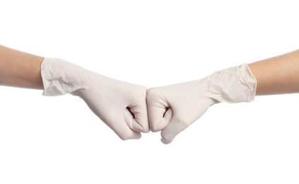 Photo of Doctors in medical gloves making fist bump on white background, closeup