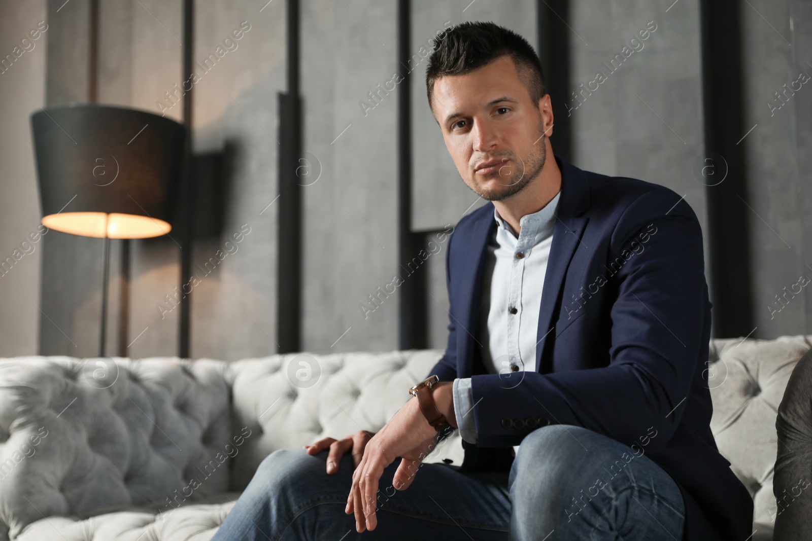 Photo of Handsome businessman on sofa indoors. Luxury lifestyle