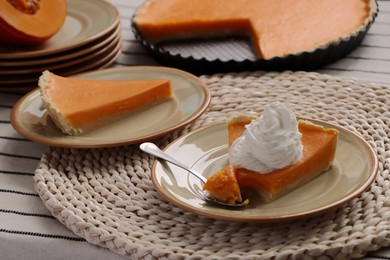 Photo of Fresh homemade pumpkin pie with whipped cream on table