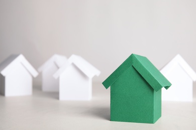 Green and white house models on light background