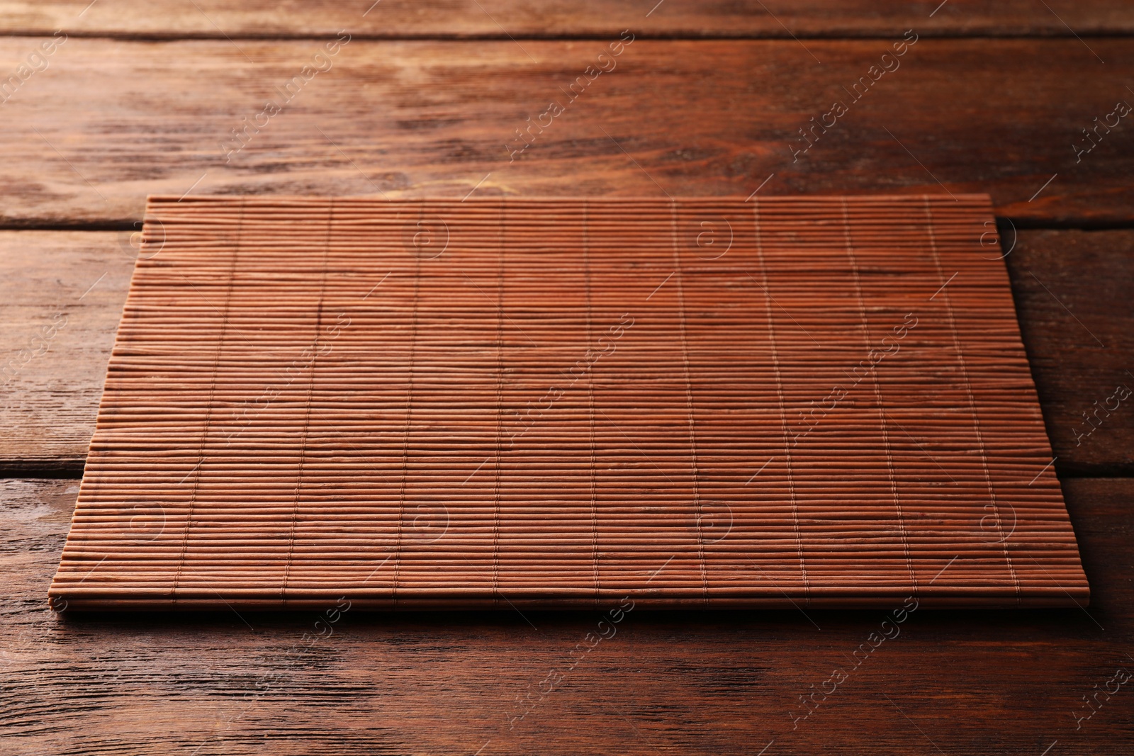 Photo of New bamboo mat on wooden table. Space for text