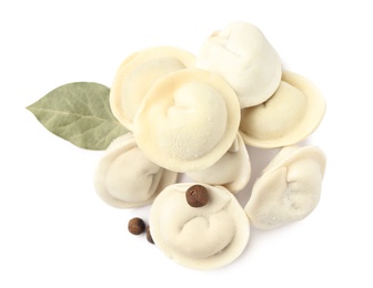 Photo of Pile of raw dumplings with bay leaf and pepper on white background, top view