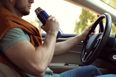 Photo of Man with thermos driving car, closeup view