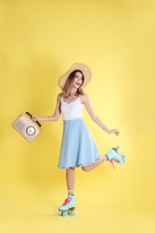 Young woman with roller skates and retro radio on color background