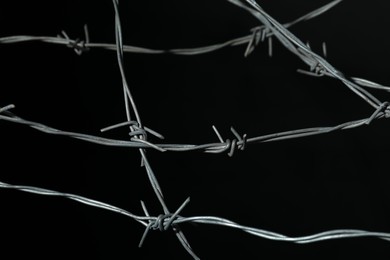 Photo of Shiny metal barbed wire on black background