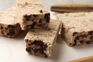 Photo of Pieces of tasty chocolate halva on board, closeup