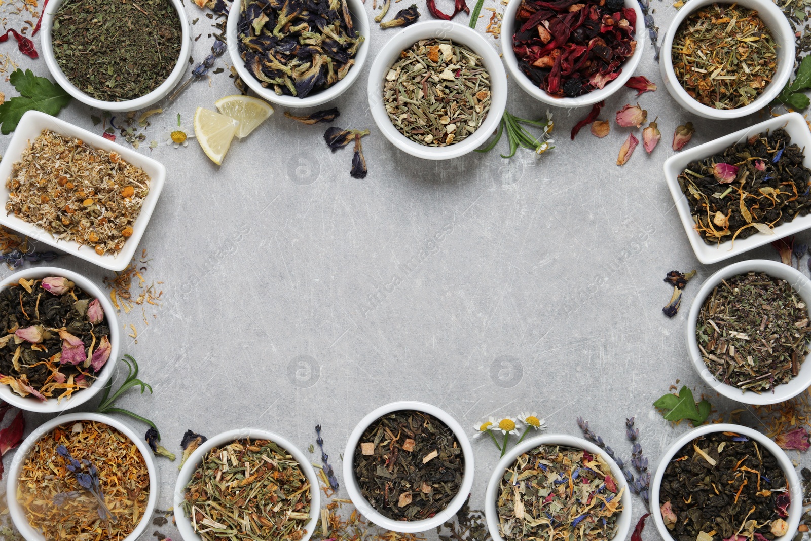 Photo of Frame of different dry teas on light grey table, flat lay. Space for text