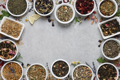 Frame of different dry teas on light grey table, flat lay. Space for text