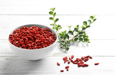 Bowl of dried goji berries on white wooden table. Healthy superfood