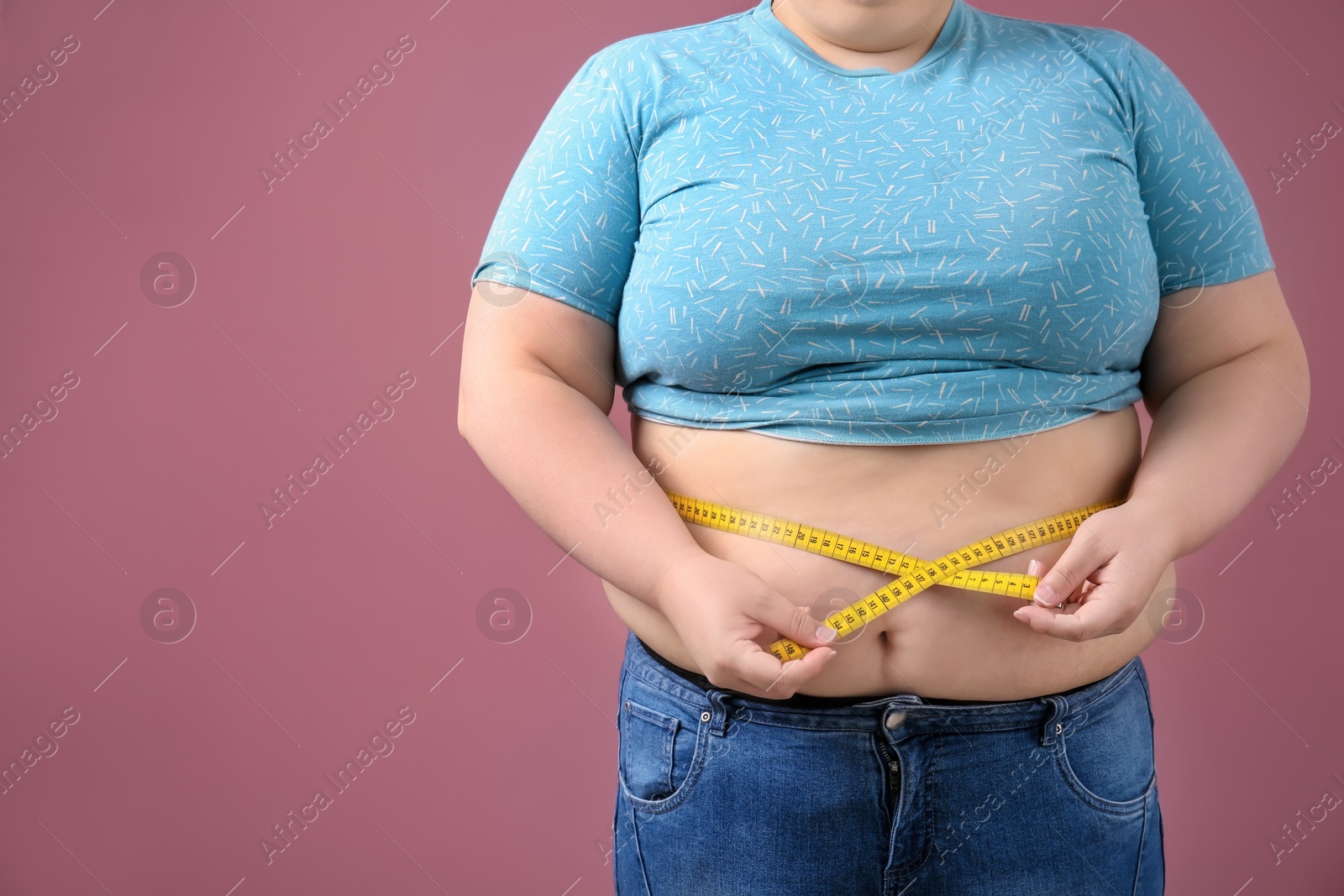 Photo of Overweight woman with measuring tape on color background