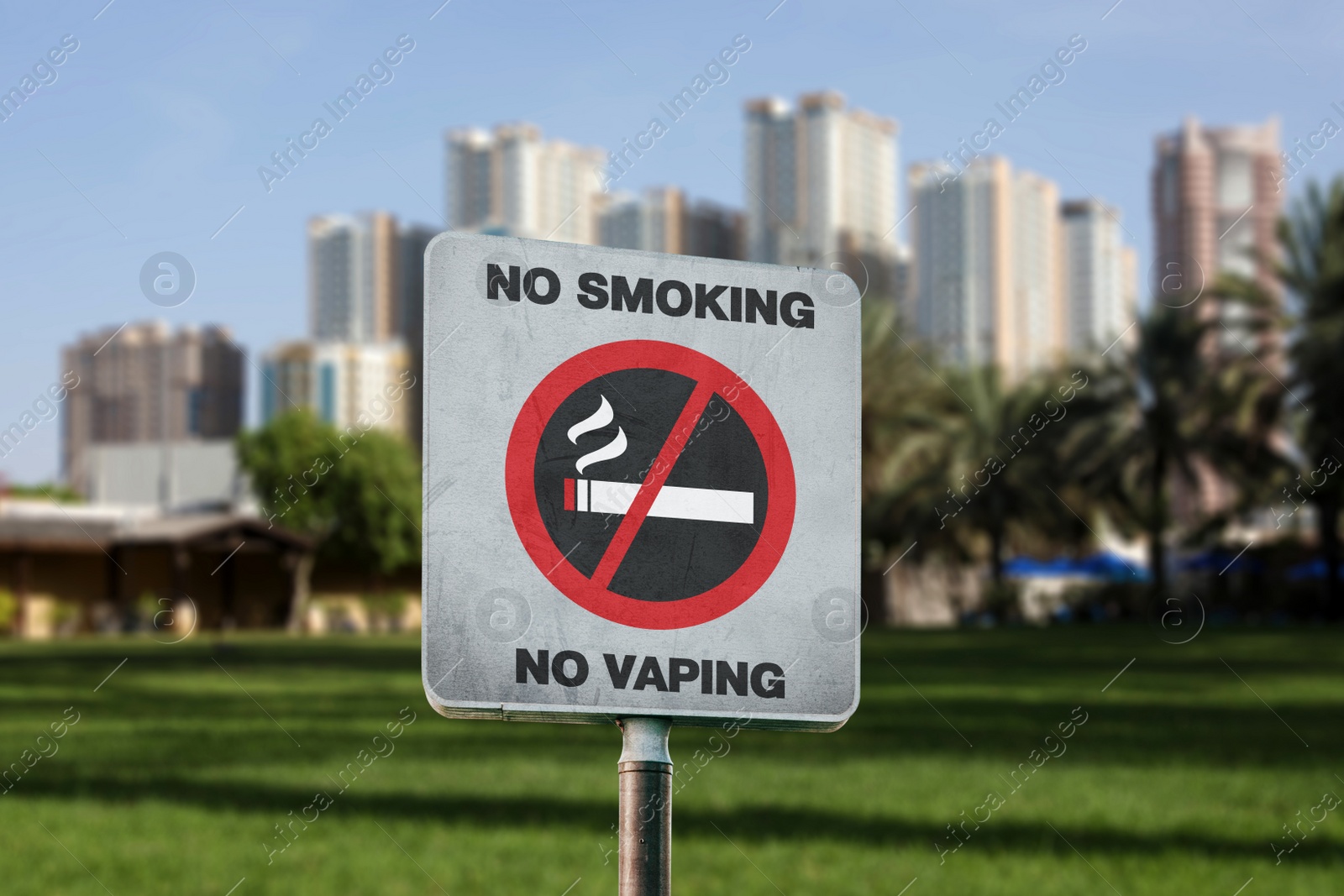 Image of Sign No Smoking and blurred view of green park and cityscape