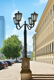 Photo of Beautiful old fashioned streetlight near building on city street