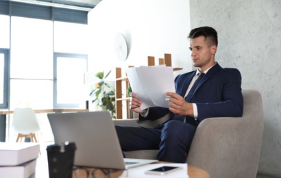 Photo of Male business trainer working with documents in office