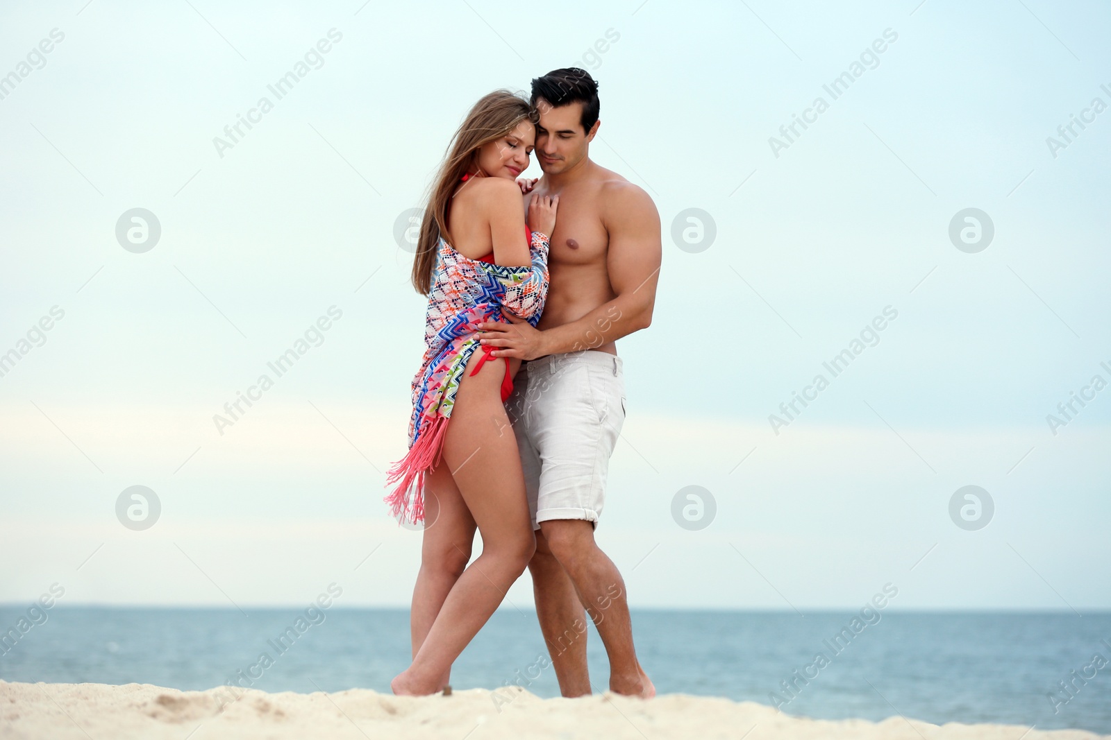 Photo of Happy young couple spending time together on sea beach