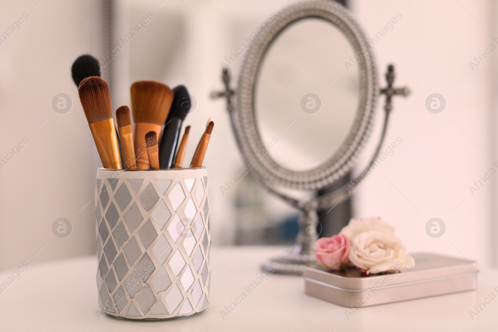 Photo of Holder with makeup brushes on table