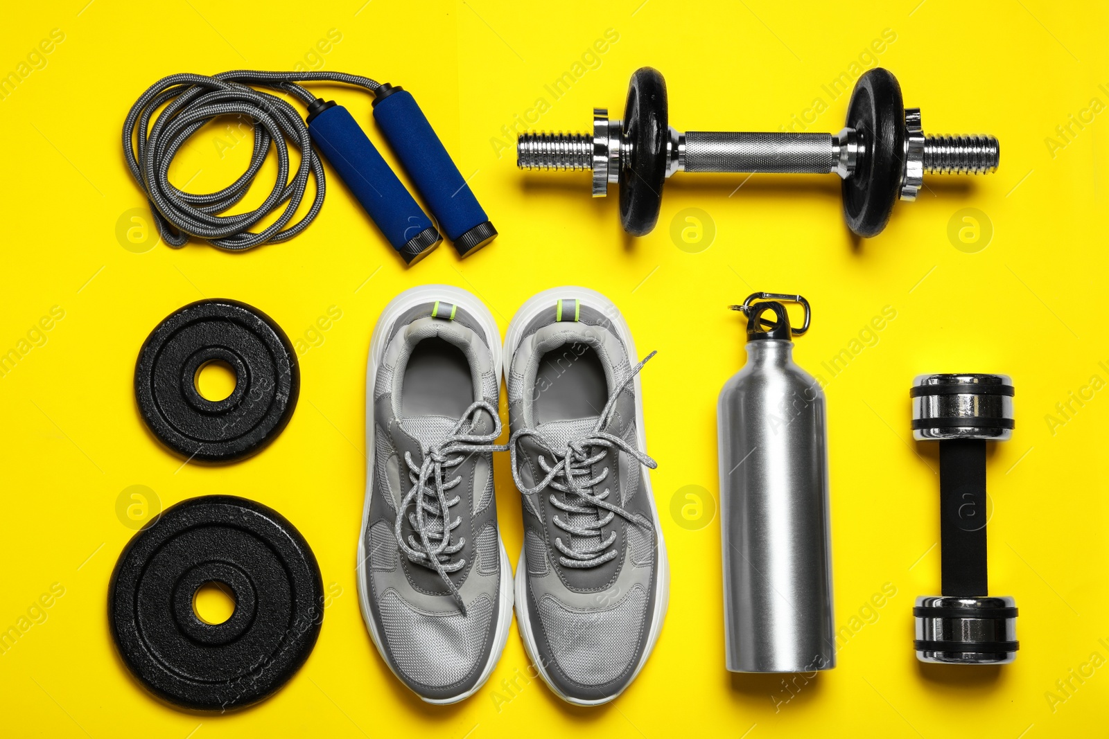 Gym equipment on yellow background, flat lay Photo of Gym equipment on yellow background, flat lay