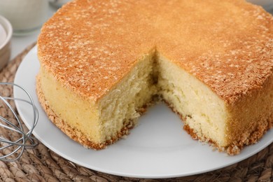 Photo of Cut tasty sponge cake on table, closeup