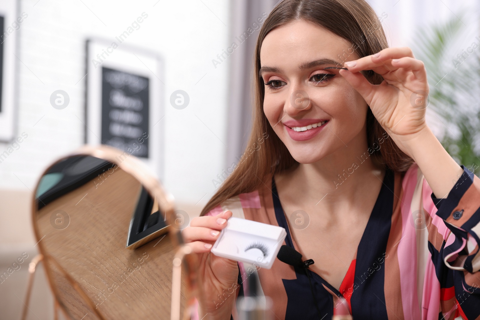 Photo of Beauty blogger applying false lashes at home