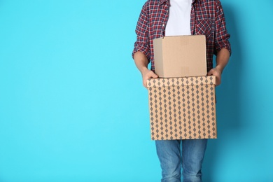 Photo of Man with moving boxes on color background. Space for text