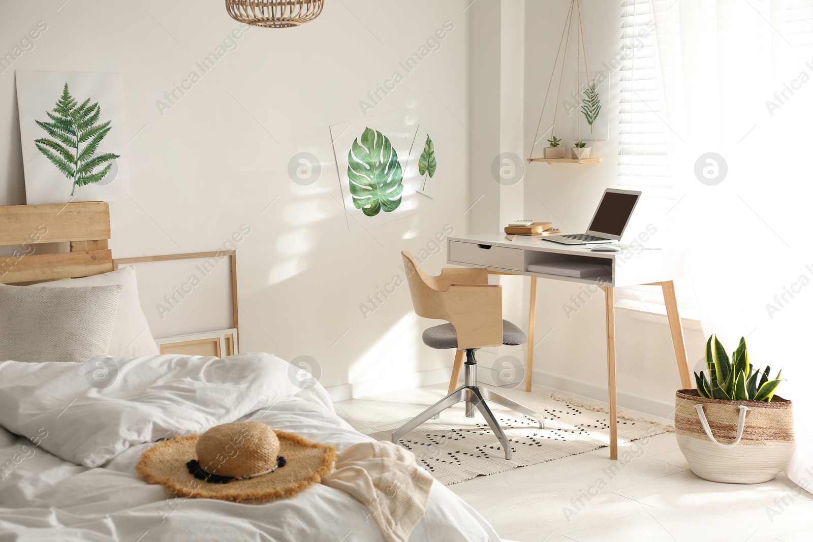 Photo of Stylish room interior with workplace and bed