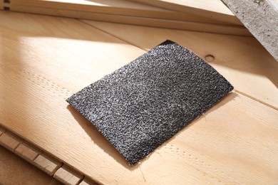 One coarse sandpaper on wooden planks, closeup