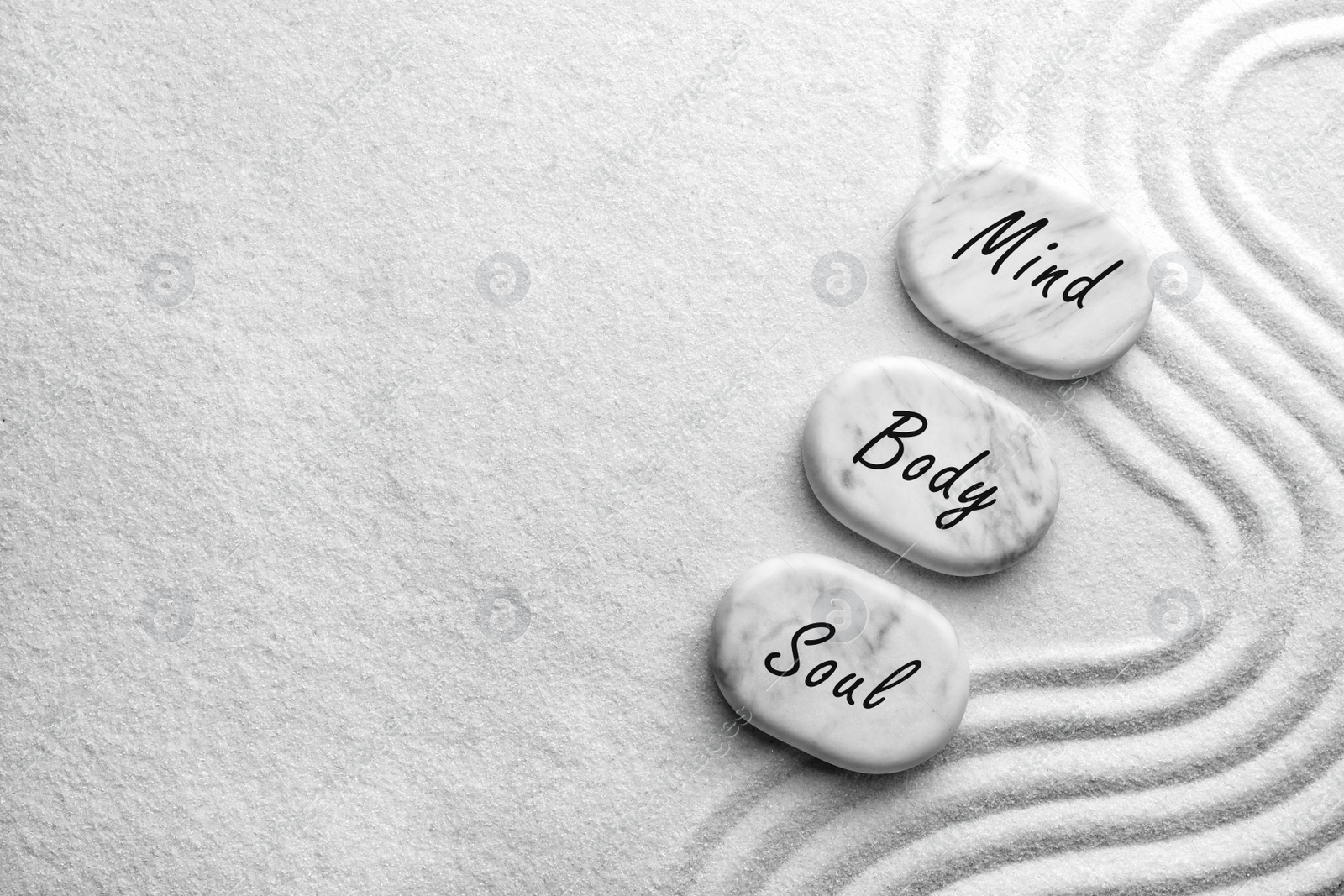 Image of Stones with words Mind, Body, Soul on sand, flat lay. Zen and harmony 