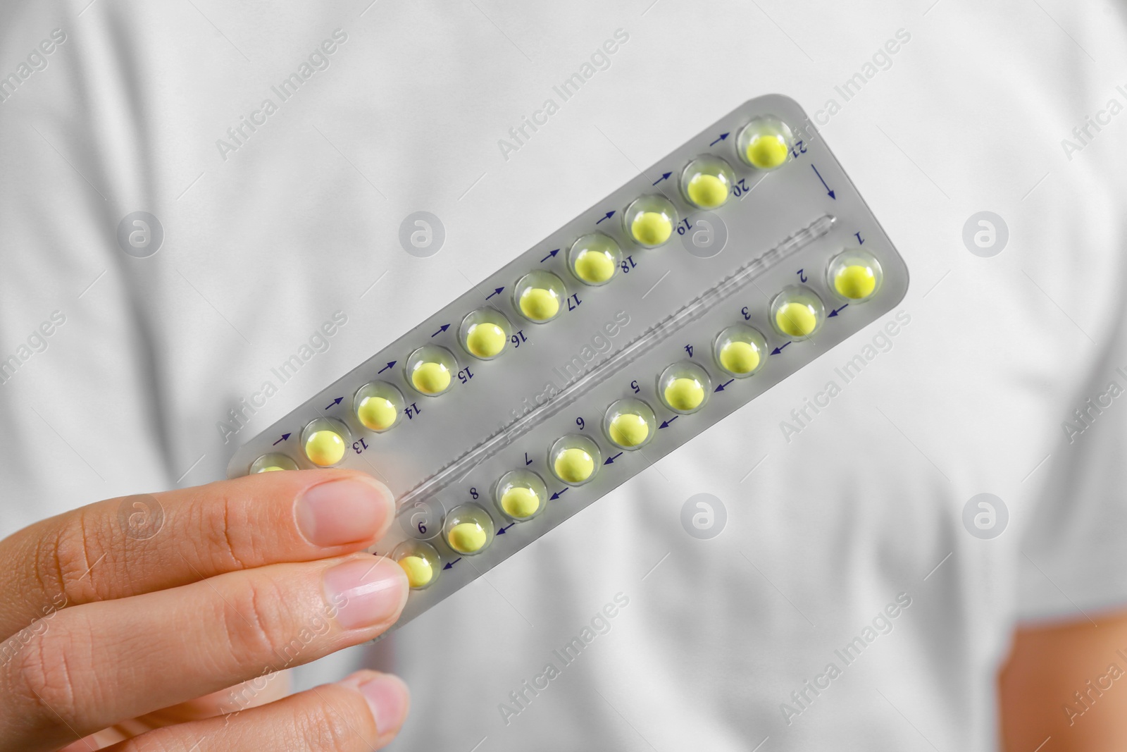 Photo of Woman holding blister with birth control pills, closeup