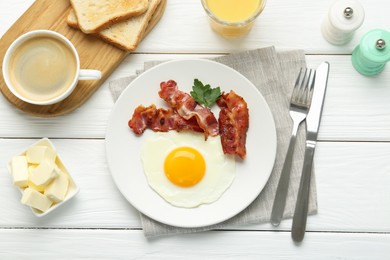 Photo of Delicious breakfast with sunny side up egg served on white wooden table, flat lay