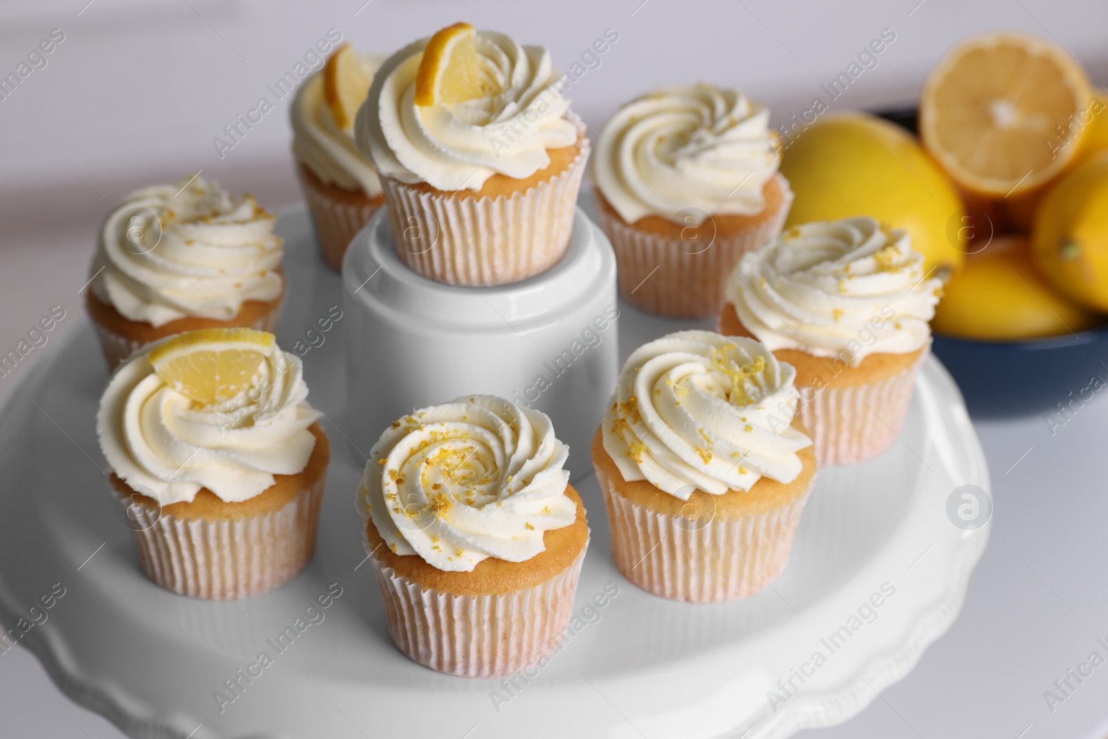 Photo of Delicious lemon cupcakes with white cream on table, closeup