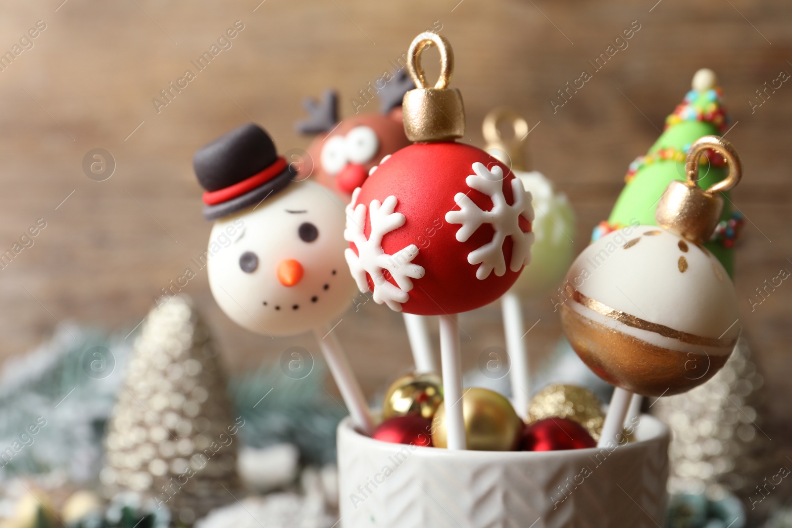 Photo of Delicious Christmas themed cake pops on blurred background, closeup