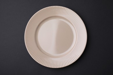 Photo of One clean plate on black background, top view