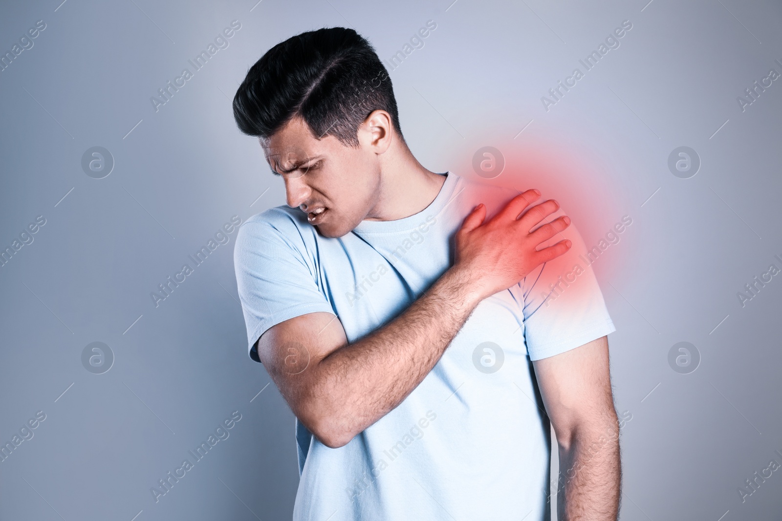 Image of Man suffering from shoulder pain on grey background