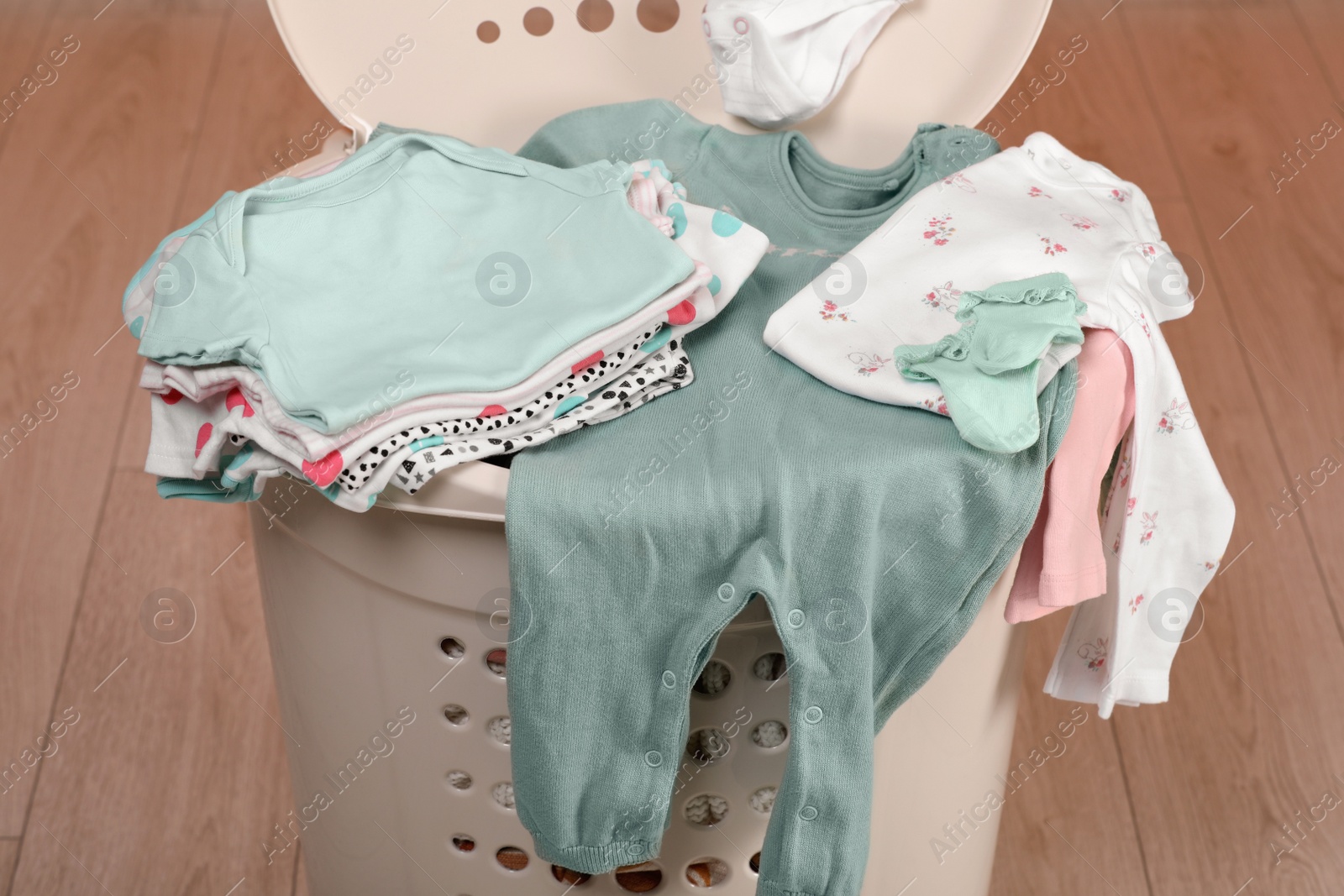 Photo of Laundry basket with baby clothes indoors, closeup