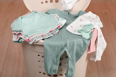 Laundry basket with baby clothes indoors, closeup