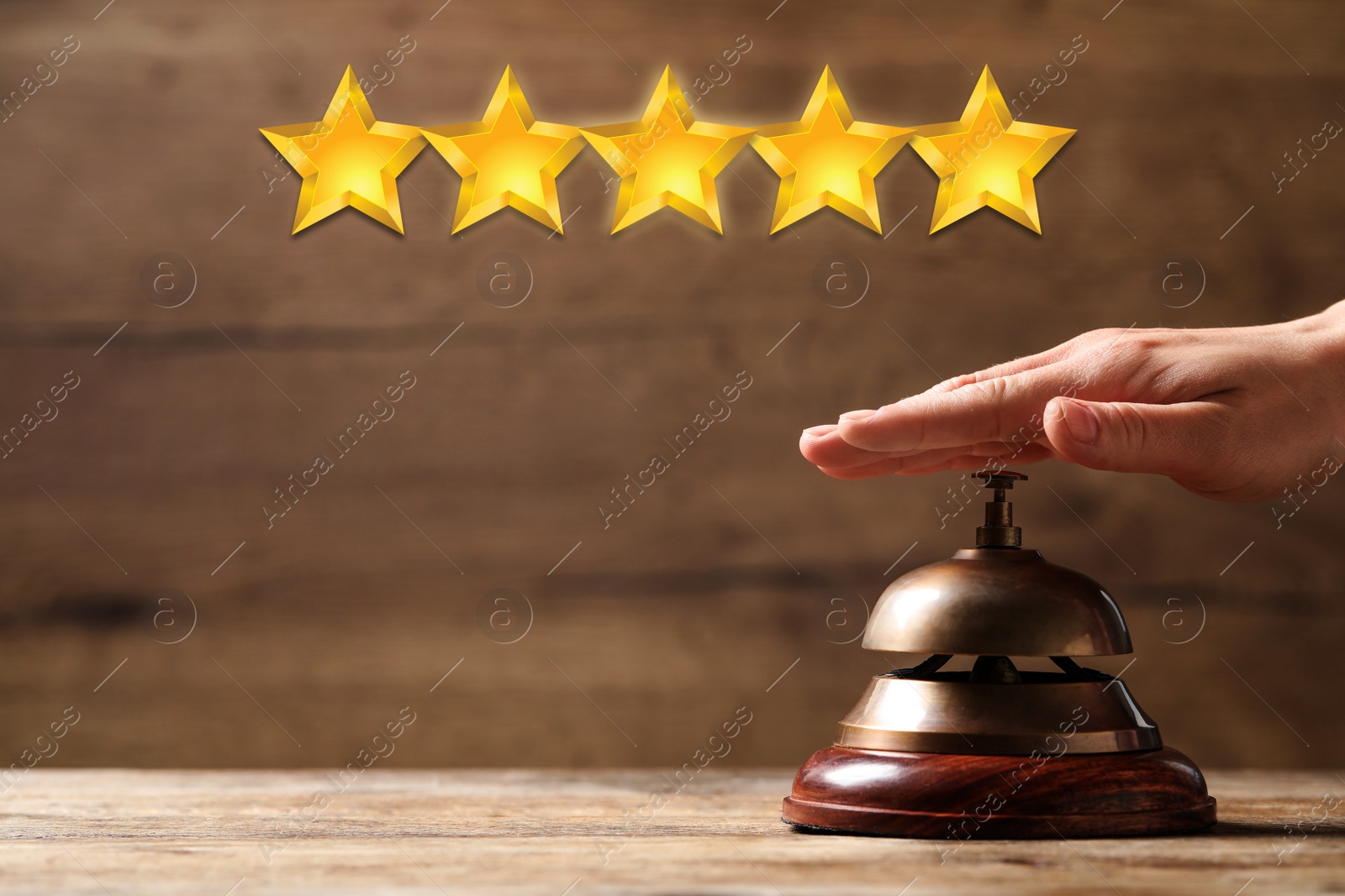 Image of Five Star Luxury Hotel. Woman ringing service bell at wooden table, closeup