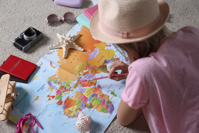 Photo of Woman with world map planning trip at home, closeup. Summer vacation