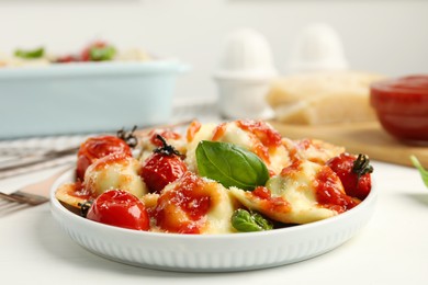 Tasty ravioli with tomato sauce served on white table