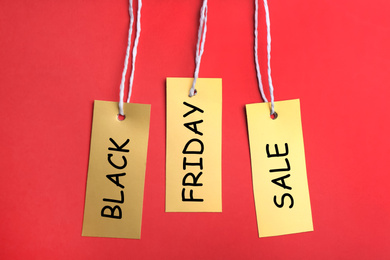 Photo of Blank golden tags on red background, flat lay. Black Friday concept